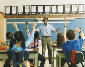 Teacher Standing in Front of a Class of Raised Hands