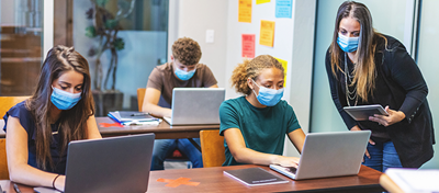 Masked teacher and students in classroom